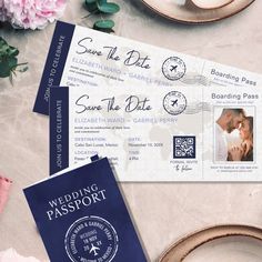 two passport style wedding cards on a table with pink flowers and teacups in the background