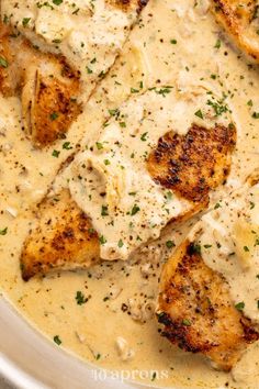 a bowl filled with chicken and gravy on top of a table