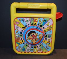 a bright yellow children's learning toy with cartoon characters on the front and sides