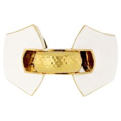 From David Webb's iconic Manhattan Minimalism collection, this exquisite ivory white enamel cuff bracelet is a true work of art. Expertly crafted in 18 karat yellow gold. The cuff's unique shape and size make it a statement accessory. The inner dimension of the cuff measures 6 inches, ensuring a comfortable and secure fit, while the outer dimensions measure 1 inch wide and 1.6 inches at its tallest part, making it a true statement piece. This David Webb cuff bracelet is a must-have for any jewel David Webb, American Modern, Ivory White, White Enamel, Cuff Bracelet, Manhattan, 6 Inches, Cuff Bracelets, Jewelry Collection