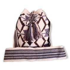 This KASHI Wayuu Mochila Bag is a unique piece of Colombian craftsmanship. It is hand-woven in the traditional style of the Wayuu people of Colombia, who are known for their intricate designs and colorful patterns. The bag features a long shoulder strap and a classic black, brown, grey, and sand color combination that adds a timeless look. It is lightweight and comfortable to carry, making it the perfect accessory for any day or night look. With its one-of-a-kind design and beautiful colors, this KASHI Wayuu Mochila Bag is sure to be the perfect addition to your wardrobe. Features & Benefits: Height of WAYUU Mochila Bag: 10 in, Base of WAYUU Mochila Bag: 7 in, Strap Length of WAYUU Mochila Bag: 44 in Each Wayuu handbag is entirely handmade, making it one-of-a-kind. Minor variations and imp Traditional Bucket Bag With Weaving For Travel, Traditional Weaving Bucket Bag For Travel, White Handwoven Artisan Shoulder Bag, White Artisan Handwoven Shoulder Bag, Artisan Handwoven White Shoulder Bag, Artisan White Handwoven Shoulder Bag, Traditional Rectangular Crochet Bag With Adjustable Strap, Traditional White Handwoven Bag, Traditional Woven Tote Bucket Bag