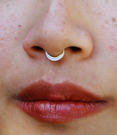 a woman's nose with a ring on top of her nose and the bottom part of her nose