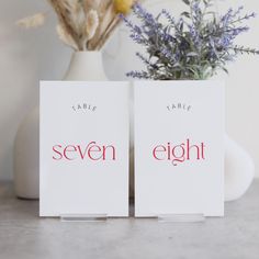 two white cards with the words seven eight printed on them next to a flower vase