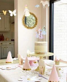 a table topped with a cake covered in frosting next to a mirror and window