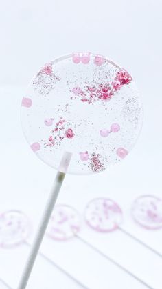 a candy lollipop with pink sprinkles on it and white background