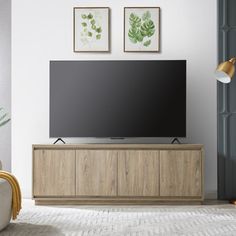 a flat screen tv sitting on top of a wooden cabinet