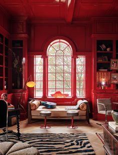 a living room filled with furniture and red walls