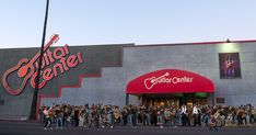 a large group of people standing in front of a building with a guitar center sign