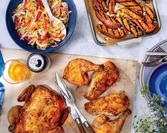 chicken, carrots and coleslaw are on a cutting board next to other dishes