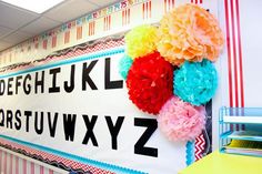 a classroom wall decorated with flowers and letters