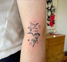 a person with a tattoo on their arm that has stars in the middle of it