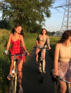 three girls are riding bicycles down the road