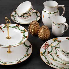 a table topped with plates and cups filled with christmas decorations on top of each other