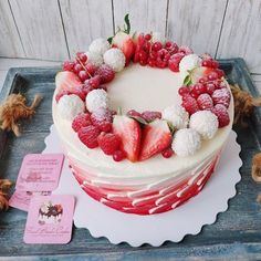 a cake with strawberries, raspberries and powdered sugar on the top