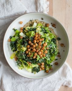 a white plate topped with lettuce and chickpeas