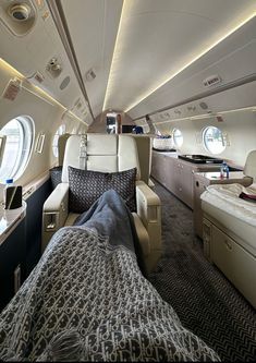 the inside of an airplane with two beds and couches on each side of it