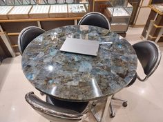 a table with chairs and a laptop on it in a room filled with glass cases