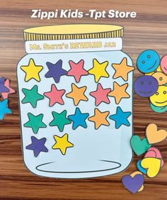 a jar filled with lots of colorful stars next to cut outs on top of a wooden table