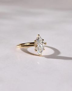 a yellow gold ring with a pear shaped diamond