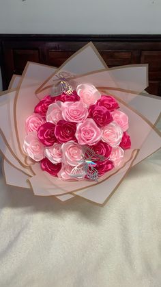 a bouquet of pink roses sitting on top of a bed