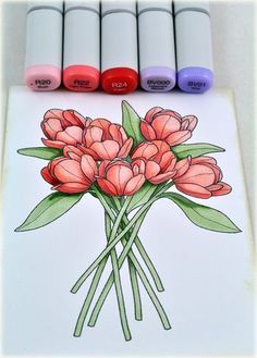 some crayons and markers are next to a drawing of flowers