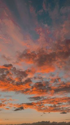 an airplane is flying in the sky at sunset or sunrise with pink clouds above it