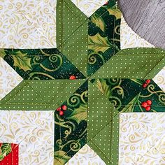 a green and white star quilted on top of a wooden table