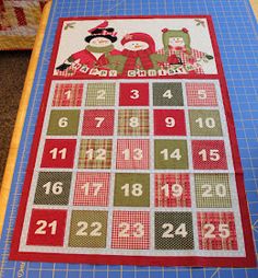 a quilted table runner with numbers on it and a christmas themed placemat in the middle