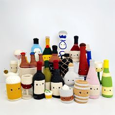 a group of crocheted wine bottles sitting next to each other on a white surface