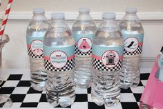 four water bottles sitting on top of a checkered table