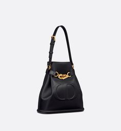 New for Fall 2023, the C'est Dior bag is an elegant and timeless creation. Crafted in black calfskin, it is distinguished by the embossed CD signature on the front, testifying to the House's savoir-faire. Thanks to its CD Lock closure with a twisting letter D, the bucket bag can keep the essentials secure. A top handle and adjustable, removable chain strap with a leather insert allow the medium bag to be comfortably carried by hand or worn over the shoulder.. Tas Celine, Womens Designer Bags, Dior Book Tote, Medium Bag, Christian Dior Couture, Luxury Designer Handbags, Dior Couture, Letter D, Fashion Jewelry Earrings