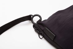 Made from a black Nylon and Polyester fabric with a creased appearance, this pouch is designed to follow and interact with the form of your silhouette. A playful twist in the material at the base of the bag creates a sense of movement and produces interesting folds in the fabric. A smaller internal zippered pouch creates a central divider in the main volume, creating three separate organisational compartments. Modern Black Packable Bag, Functional Nylon Shoulder Bag For Evening, Versatile Black Packable Shoulder Bag, Versatile Packable Black Shoulder Bag, Versatile Black Foldable Shoulder Bag, Black Nylon Pouch With Removable Section, Black Nylon Pouch For Daily Use, Black Foldable Shoulder Bag For Travel, Black Foldable Shoulder Bag For Daily Use