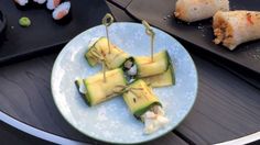 several pieces of sushi on a plate with chopsticks next to the plates