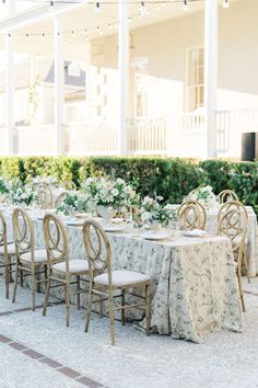 an outdoor dining area with tables, chairs and flowers on the tablecloths is shown