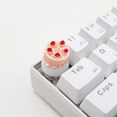 a small cake sitting on top of a computer keyboard