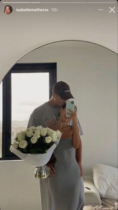 a man and woman taking a selfie in front of a mirror with flowers on it