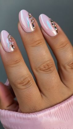 a woman's hand with pink and silver nail polish on her nails, holding a pink cup