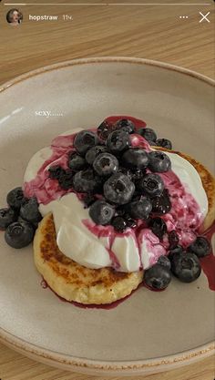 a white plate topped with blueberries and whipped cream