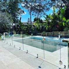 an empty swimming pool surrounded by greenery and fenced in area with trees on both sides