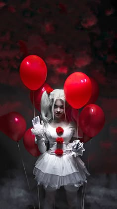 a woman in white dress holding red balloons