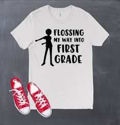 "It's that time again! Back to school we go! What better way to go than dressed in this awesome back to school design. The design is made on a white or black short sleeve tee with black or white heat transfer vinyl for the words \"Flossing my way into -- Grade\". Let us know in comments to seller which color shirt you want. This shirt would also be perfect for teachers too! Choose your grade level from the options! Youth Sizes: XS - 5T Small 6-7 Medium 8 Large 10-12 Adult Sizes: X-small Small Me Fun School Tops With Funny Text, End Of School Year Text Print Shirt, Fun School Shirt With Funny Text, Back To School Tops With Funny Text, School Spirit Funny Print Short Sleeve Shirt, Fitted Letter Print T-shirt For School, Casual Shirt For College End Of School Year, School Spirit Shirt With Slogan For School, School Spirit Shirt With Slogan