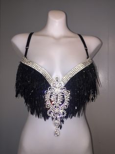 a mannequin wearing a black and white bralet with feathers on the chest