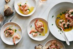 several plates with shrimp and bread on them