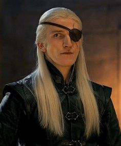 a man with long white hair wearing a black leather outfit and eye patch on his forehead