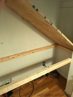 a person is working on the bottom half of a wooden rafting structure in their home