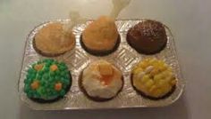 cupcakes with frosting and toppings are arranged in a muffin tin