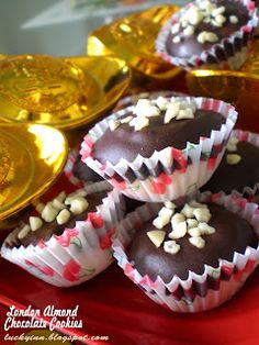 chocolates with white and red sprinkles are on a plate next to gold plates