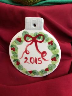 a white ornament with a red bow on it and the number 2013 painted on it