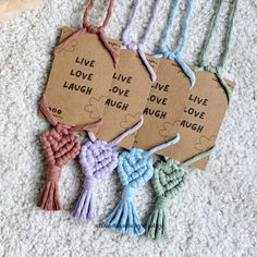 four pieces of paper with words on them and tassels attached to the strings