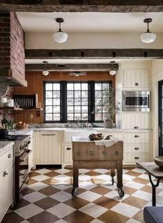 a kitchen with checkered flooring and white cabinetry, windows, and an island